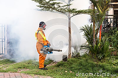 Worker fogging residential area with insecticides to kill aedes Editorial Stock Photo