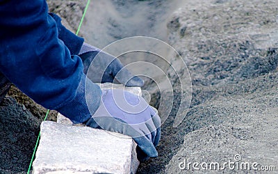 Hands placing out cobblestone in the ground Stock Photo