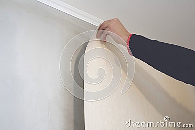 Worker glues wallpaper on the wall. Home repair concept Stock Photo