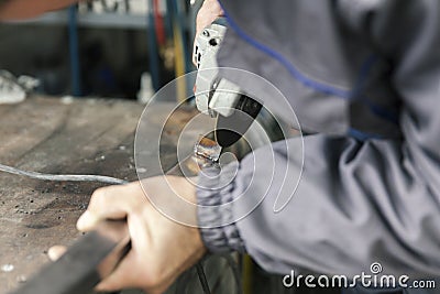 Worker grinds metal rods Stock Photo