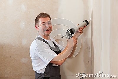 Worker grouts with silicone Stock Photo