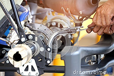 Worker hand tightening or loosening a nut of a bolt with a wrench for automotives part Stock Photo