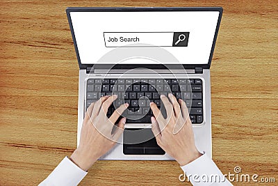 Worker hand types job search on laptop Stock Photo