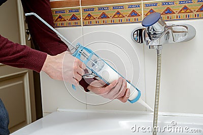 Worker hands applying silicone sealant. Stock Photo