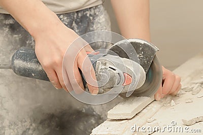 Worker hands cutting a tile Stock Photo