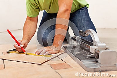 Worker hands laying ceramic floor tiles Stock Photo