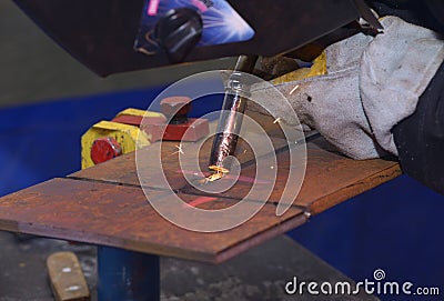 worker hands welding metal plates with semi-automatic welder at a workshop Stock Photo