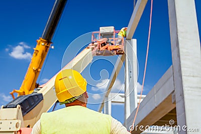 Worker is helping crane from the ground, keep balance and direction Editorial Stock Photo