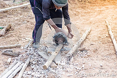 The worker holding wood cutter and cutting wood Editorial Stock Photo