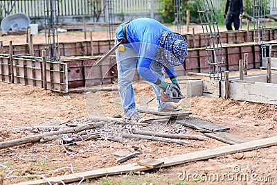 The worker holding wood cutter and cutting wood Editorial Stock Photo