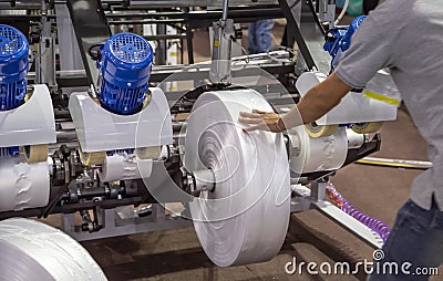 Worker install film roll for plastic bag extruder machine Stock Photo