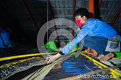 Worker install thermal heat insulation on roof Editorial Stock Photo