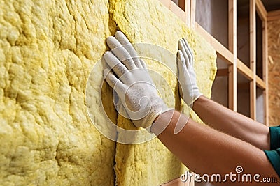 Worker installing mineral wool filling used as isolation material in walls Stock Photo