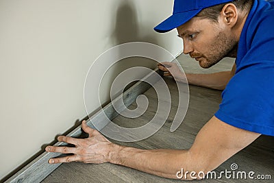 Worker installing skirting board, baseboard Stock Photo