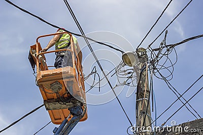 Worker installs new cables on an electric pole Stock Photo