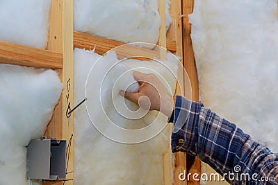 Worker in insulating rock wool insulation in wooden frame for future house walls for warm home Stock Photo