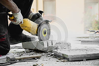 Worker cutting limestone block with power tool saw Stock Photo