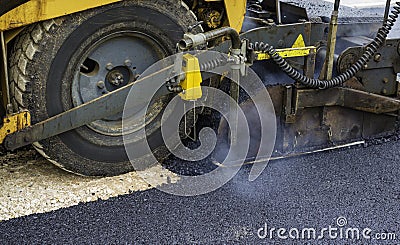 Worker leads the vibrating road roller to compact the asphalt Stock Photo
