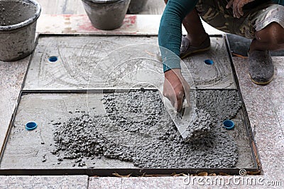 Worker leveling cement of drain hose with trowel Stock Photo
