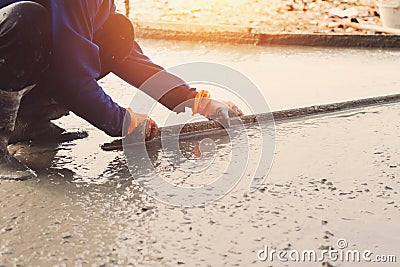 worker leveling concrete pavement for mix cement at construction Stock Photo