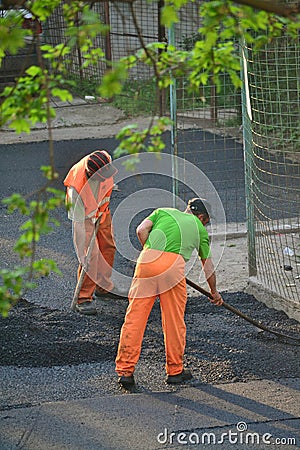 Worker leveling fresh asphalt Editorial Stock Photo