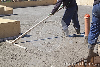 worker leveling fresh concrete slab with a special working tool Editorial Stock Photo