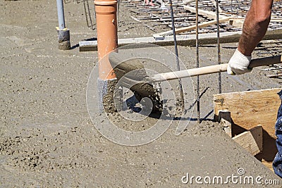 worker leveling fresh concrete slab with a special working tool Stock Photo