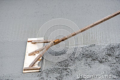 Worker leveling with trowel uneven fresh concrete at house building Stock Photo