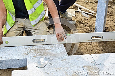 Worker levels installed paving with a spirit level. Stock Photo