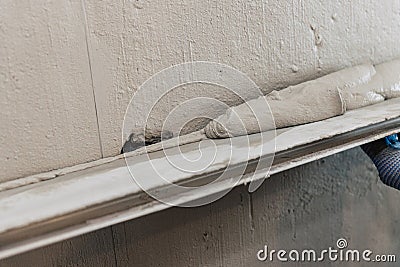 A worker levels the plaster with a leveler Stock Photo