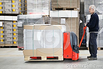 Worker With Loaded Handtruck In Warehouse Stock Photo