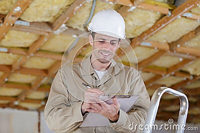 Worker making notes on clipboard during property renovation Stock Photo