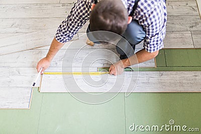 Worker Man laying laminate flooring at home room Stock Photo