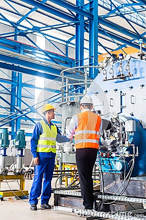 Worker and manager in industrial factory Stock Photo