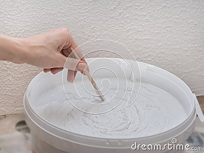 Worker mixes construction putty in a bucket. Stock Photo