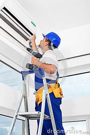 Worker mounting air conditioning unit Stock Photo