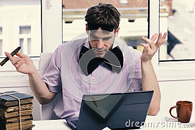 Worker near old books on window background. Guy with short hair and bristle wears sunglasses Stock Photo