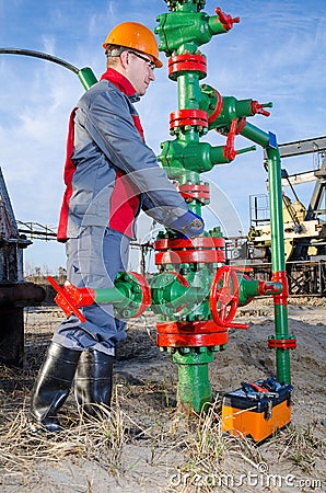 Worker in the oilfield repairing wellhead Stock Photo