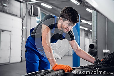 Workshop worker looking under the hood of a car Stock Photo