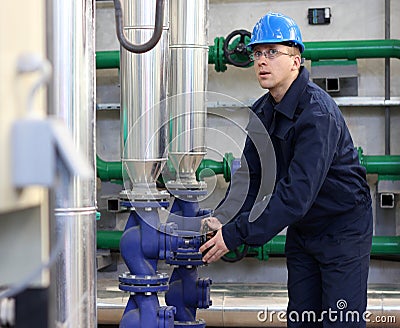 Worker opens a valve in plant Stock Photo