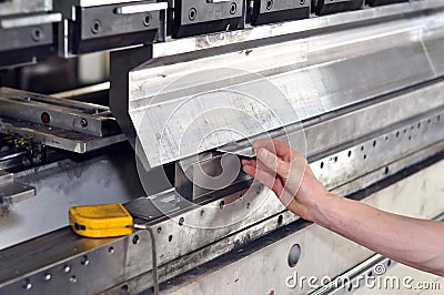 Worker operates bending machine in a metal construction company Stock Photo