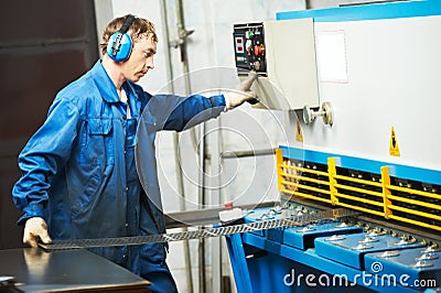 Worker operating guillotine shears Stock Photo