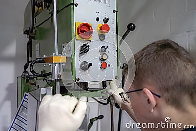 The worker operator of a mechanically controlled drilling machine performs work Stock Photo