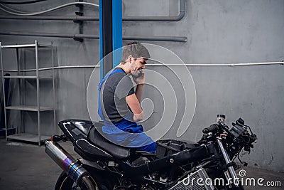 A man is sitting on a bike calling a client Stock Photo