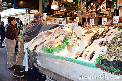 A worker packs fresh fish in ice Editorial Stock Photo