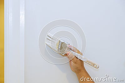 Worker are painting in the door trim molding on a white wall Stock Photo