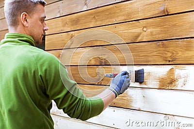 Worker painting house exterior with wood protective color Stock Photo