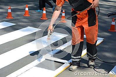 Worker is painting a pedestrian crosswalk. Technical road man worker painting and remarking pedestr Stock Photo