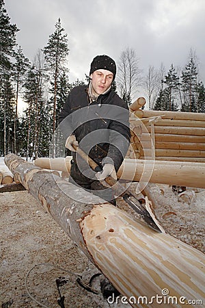 Worker peeled timber for log cabin construction using debarking Editorial Stock Photo