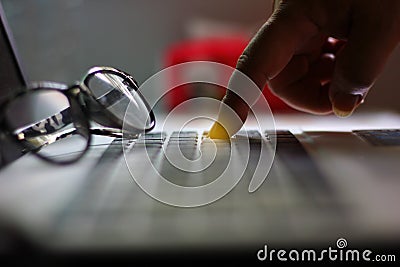 The worker pointing finger on button of laptop.worker is push button delete his job or push button enter tosave his work Stock Photo